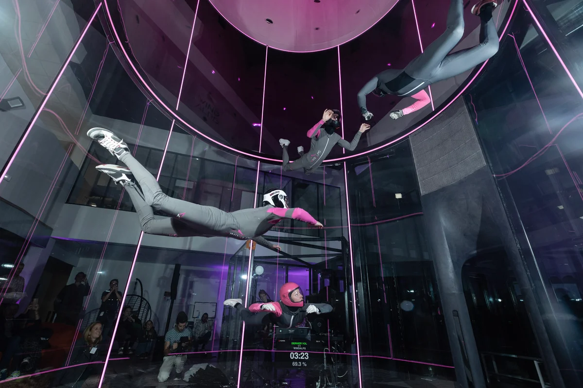 Team-Training auf höchstem Niveau: Vier Flyer teilen sich die Flugkammer des TT45 PRO bei Wind Alps in Frankreich. Der 8 Meter hohe, perfekt runde Glaszylinder besteht aus mehrschichtigem, schallabsorbierendem Glas und bietet Zuschauern optimale Sicht bei reduzierter Lautstärke. Ein Telemetrie-Display direkt auf der Glasoberfläche liefert den Sportlern Echtzeitdaten zu Flugdauer und Luftgeschwindigkeit.