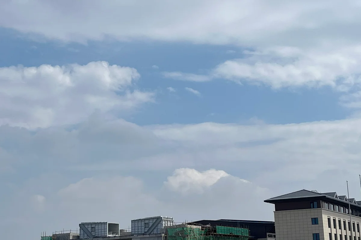 Spoljašnji izgled radova u toku na lokaciji projekta China Flight Town. Objekat sadrži TunnelTech TT43 Smart vertikalni aerodinamički tunel. Skele i zelena zaštitna mreža prekrivaju fasadu zgrade, dok su na gornjem nivou vidljive mehaničke strukture kućišta za petlju tunela. Gradilište se nalazi pored završenog sportskog terena sa veštačkom travom. Ova instalacija ima prečnik letne komore od 4,3 metra, pogodan za profesionalnu obuku i komercijalne operacije.