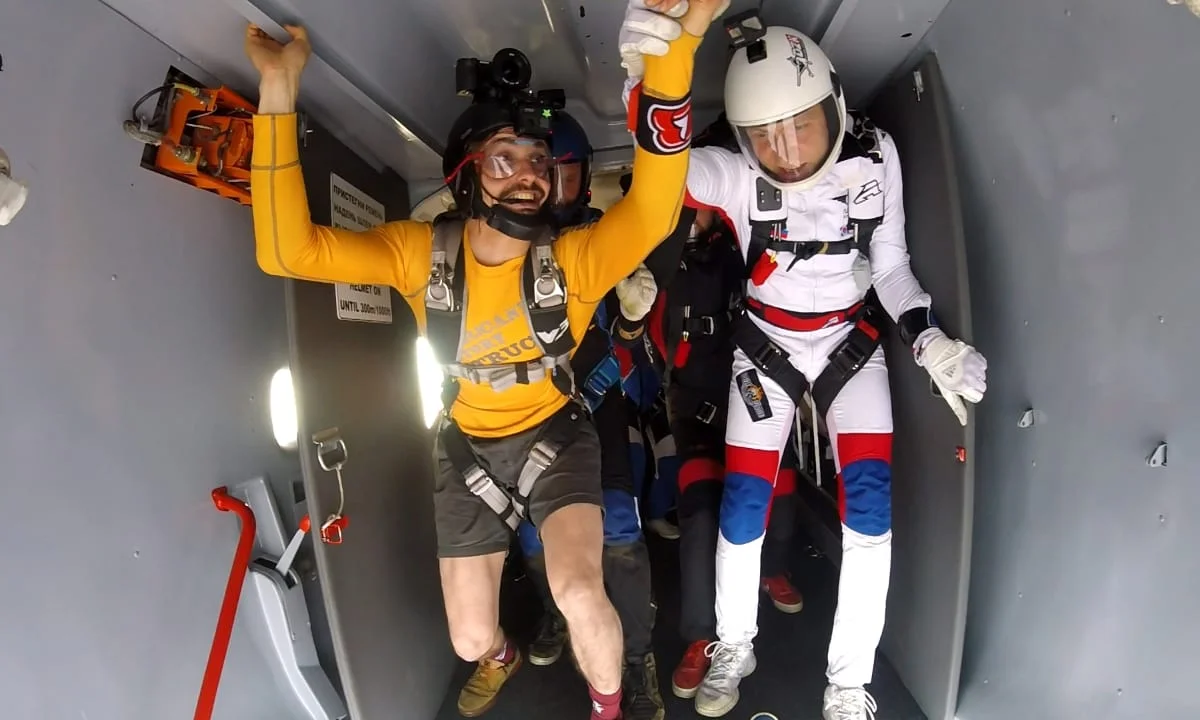 Questa foto mostra il team di top management di TunnelTech mentre si prepara a uscire dall’aereo con le loro attrezzature per il paracadutismo