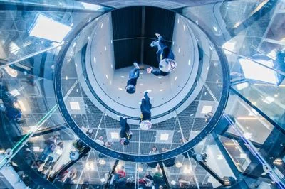Four pro flyers diving down at high speed during a dynamic routine in the TT45 PRO flight chamber.