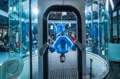 Two flyers execute a stacked entrance stunt at the FlyStation Sakura Cup, with one athlete standing on the inverted partner's back.