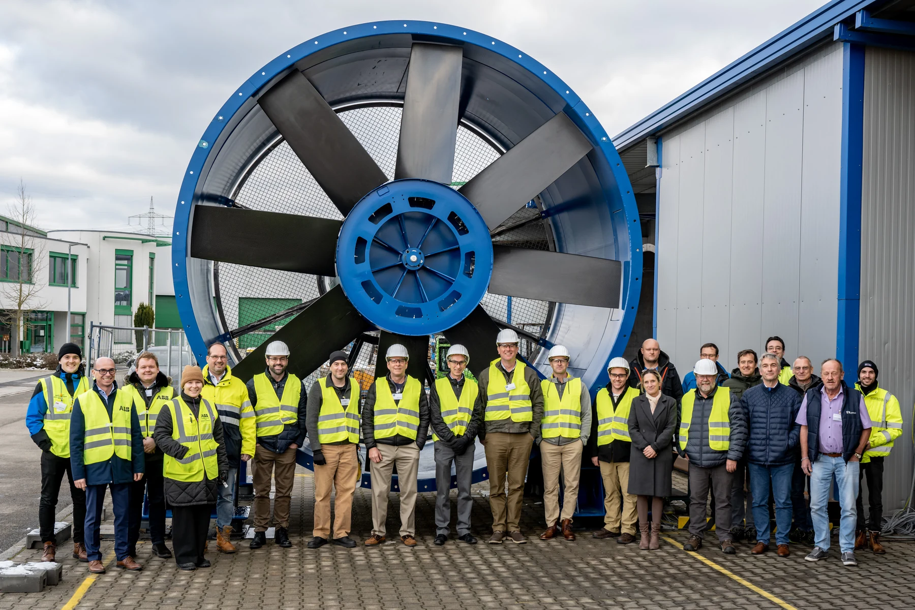 Engineers and project partners with a large EVG axial fan