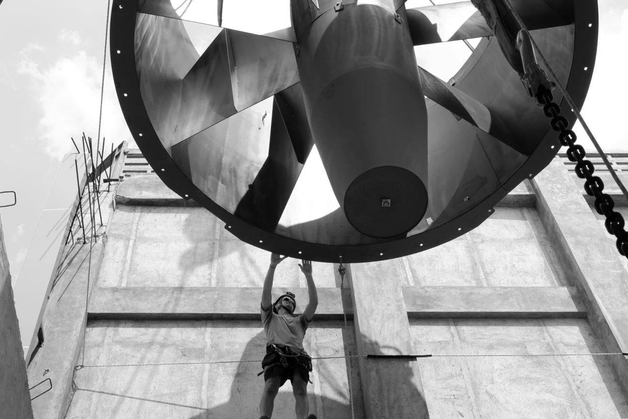 TunnelTech installation team lifting a fan into position at a project site